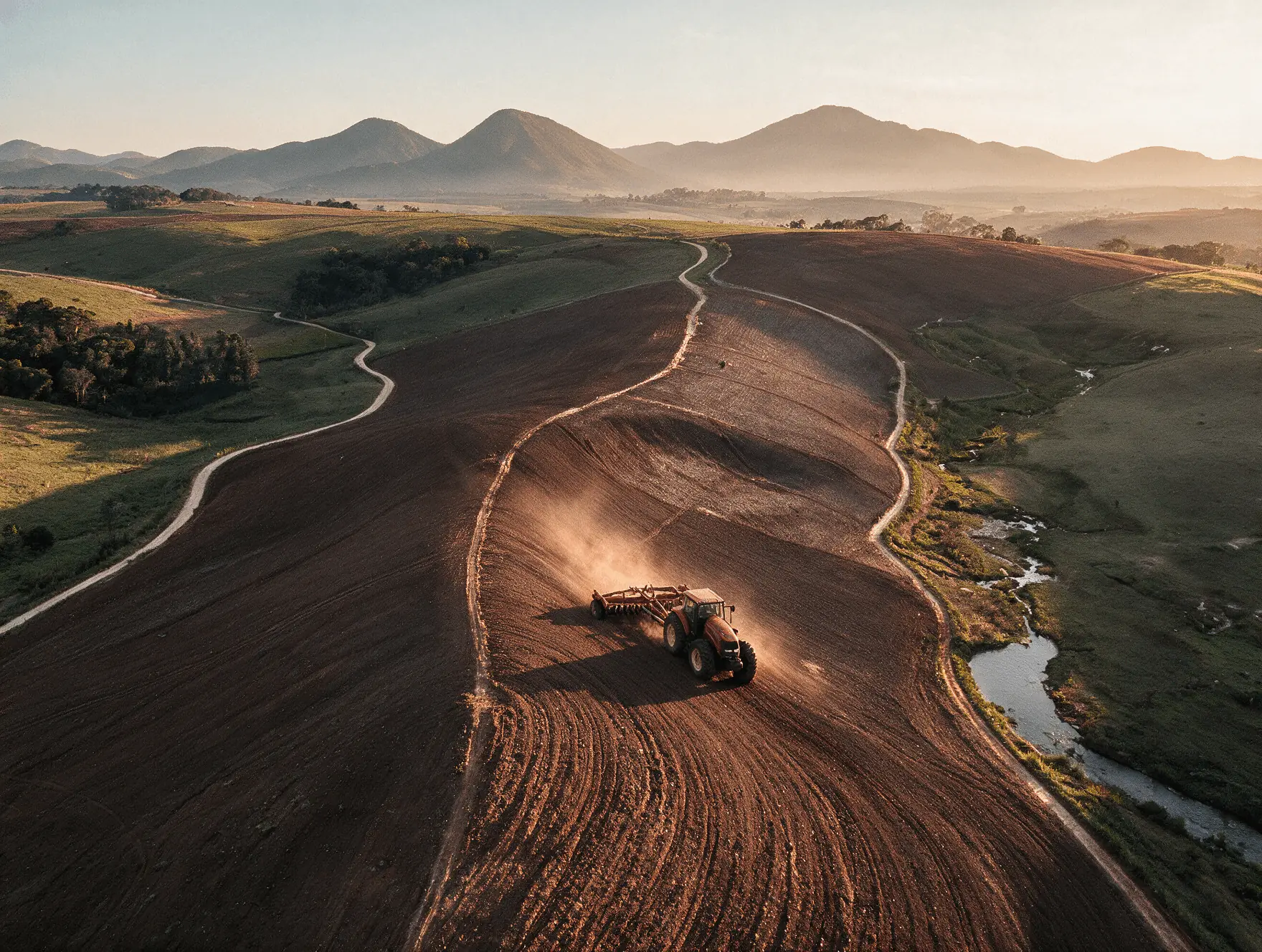 Trator arando a terra em encosta nas montanhas capixabas